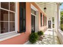 Inviting porch with black shutters, ferns, and a view of the charming architecture at 17 Wentworth St, Charleston, SC 29401