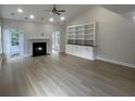 Bright living room with light wood floors, fireplace, built-in shelves, and French doors at 208 Molasses Mill Ct, Summerville, SC 29485