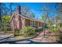 Side view of a brick home with manicured shrubs and a walkway leading to the entrance at 210 Padgett Loop, Walterboro, SC 29488