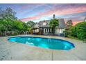 Inviting backyard oasis featuring a sparkling pool, a covered patio, and lush greenery for outdoor relaxation at 23 Forde Row, Charleston, SC 29412