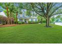 Beautiful home featuring a lush green lawn, complemented by mature trees and meticulously maintained landscaping at 23 Forde Row, Charleston, SC 29412