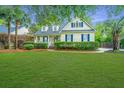 Charming two-story home featuring a well-manicured lawn and blue shutters, creating a welcoming curb appeal at 23 Forde Row, Charleston, SC 29412
