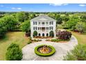 Elegant two-story home with circular driveway, fountain, and manicured landscaping at 2636 Anchor Watch Dr, Wadmalaw Island, SC 29487