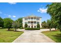 Charming two-story home with a circular driveway and a meticulously landscaped fountain at 2636 Anchor Watch Dr, Wadmalaw Island, SC 29487