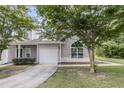 Light gray townhouse featuring an attached garage and classic curb appeal with mature trees at 281 Jackson St, Goose Creek, SC 29445