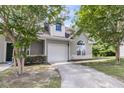 Light gray townhouse featuring an attached garage and classic curb appeal, shaded by mature trees at 281 Jackson St, Goose Creek, SC 29445