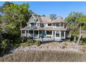 Stunning multi-story home boasting wraparound porches, mature landscaping, and waterfront views at 3104 Upda Creek, Seabrook Island, SC 29455