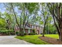 Beautiful brick home nestled among mature trees, featuring a well-manicured lawn and inviting entrance at 312 E Shepard Ln, Summerville, SC 29483