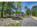Single-story home with a driveway and a large yard surrounded by mature trees at 317 Marion Rd, Dorchester, SC 29437