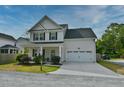 Traditional two-story home featuring a neat lawn, an attached garage, and a covered front porch with an American flag at 3208 Pecan Orchard Way, Charleston, SC 29414