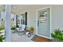Welcoming front porch with stylish seating, potted plants, and a charming 'Welcome to our Home' door sign at 3208 Pecan Orchard Way, Charleston, SC 29414