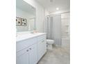 Bright bathroom with a vanity, mirror, and shower with a striped curtain, complemented by neutral tiling at 325 Tiliwa St, Summerville, SC 29486