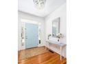 Bright foyer features hardwood floors, a stylish light fixture, and a decorative table with fresh flowers at 700 Preservation Pl, Mount Pleasant, SC 29464