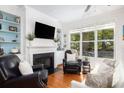 Cozy living room with a fireplace, built-in shelves, hardwood floors, and ample natural light at 700 Preservation Pl, Mount Pleasant, SC 29464
