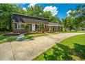 Well-maintained brick home featuring a long driveway and lush green lawn at 100 Colonial Dr, Goose Creek, SC 29445