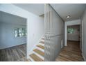 Bright foyer featuring a staircase with modern railing and wood floors at 100 Colonial Dr, Goose Creek, SC 29445