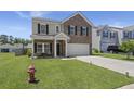 Charming two-story home with a brick facade, well-manicured lawn, and inviting front porch at 110 Levis Song Ct, Goose Creek, SC 29445