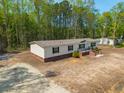 Inviting single-story home with well-kept lawn and landscaping, complete with a cozy front porch and manicured shrubbery at 120 Perry Hill Rd, Moncks Corner, SC 29461
