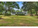 Beautiful home showcasing a well-maintained lawn, mature trees, and classic architectural details at 1986 Elaine St, Johns Island, SC 29455