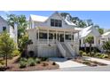 Charming two-story white home with a lovely front porch, garage, and well-manicured landscaping at 2229 Boatwright Rd, Johns Island, SC 29455