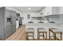 Modern white kitchen featuring stainless steel appliances, light countertops and breakfast bar at 2462 Swallow Dr, Charleston, SC 29414