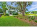 Well-manicured lawn in front of a lovely two-story house with double porches at 2596 Hatch Dr, Johns Island, SC 29455