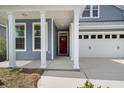 View of the home's front porch with white columns and a red front door at 267 Palmetto Walk Dr, Summerville, SC 29486
