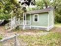 Quaint cottage featuring a fenced yard, classic window frames, and mature trees at 307 Mill St, Walterboro, SC 29488