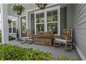 Inviting front porch with rocking chairs and hanging flower baskets at 4019 Cascades Thrust, Summerville, SC 29483