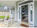 Inviting front porch with rocking chairs, columns, and decorative details at the home's entrance at 402 Bay Creek Dr, Charleston, SC 29414