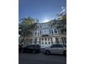 Traditional two-story facade with bay windows and grey shutters in an urban setting, surrounded by parked cars and trees at 41 Legare St # C, Charleston, SC 29401