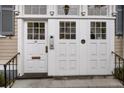 Elegant white front door with glass panels, black iron railings, and transom windows offering natural light at 41 Legare St # C, Charleston, SC 29401