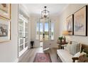 Bright foyer with hardwood floors, transom windows, modern light fixture, and a glimpse of the outdoors at 4314 Grange Cir, Summerville, SC 29486