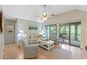 Bright living room with neutral decor, ceiling fan, and sliding glass doors leading to outdoor space at 4856 Green Dolphin Way # Share 7, Kiawah Island, SC 29455