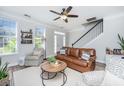 Bright living room with a leather sofa, patterned chairs, and large windows at 754 Certificate Ct, Charleston, SC 29414