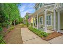 Charming two-story house featuring a welcoming front porch with an American flag on a sunny day at 78 Branch Creek Trl, Summerville, SC 29483