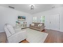 Cozy living room featuring modern white walls, dark hardwood floors, and plantation shutters at 78 Branch Creek Trl, Summerville, SC 29483