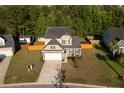 Inviting two-story home with a manicured lawn, two car garage, and charming curb appeal on a sunny day at 8035 Mckayla Rd, Summerville, SC 29483