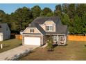 Charming two-story home boasting a two-car garage, inviting front porch, and manicured lawn on a sunny day at 8035 Mckayla Rd, Summerville, SC 29483