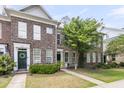 Charming brick townhome featuring a well-manicured lawn and welcoming front entrance at 822 Rue Dr, Charleston, SC 29414