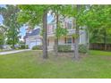 View of a two story home surrounded by trees on a well-manicured lawn at 8632 Madelyn St, North Charleston, SC 29406