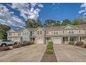 Street view showcasing charming townhomes with colorful exteriors, attached garages, and manicured landscaping at 9418 Sweep Dr, Summerville, SC 29485