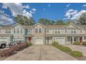 Street view showcasing charming townhomes with colorful exteriors, attached garages, and manicured landscaping at 9418 Sweep Dr, Summerville, SC 29485