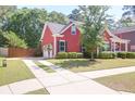 View of red house with driveway and manicured lawn at 1126 Rearick Rd, Johns Island, SC 29455