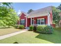 Inviting red home with manicured landscaping and covered porch at 1126 Rearick Rd, Johns Island, SC 29455