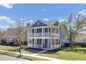 Charming two-story home boasts a double porch and lush green landscaping with a beautiful blue sky backdrop at 117 Red Leaf Blvd, Moncks Corner, SC 29461