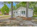 White brick home with a grey roof on a lot with mature trees at 131 Ponderosa Dr, Ladson, SC 29456