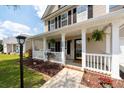 Inviting front porch featuring white columns, decorative plants, and charming curb appeal at 139 Spindle Way, Goose Creek, SC 29445