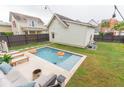 Backyard pool area featuring a pool with fountains, lounge seating, and privacy fence at 1445 Lettered Olive Ln, Mount Pleasant, SC 29464