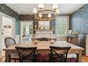 Elegant dining room with floral wallpaper, a wooden table, and a decorative chandelier at 2158 Westrivers Rd, Charleston, SC 29412